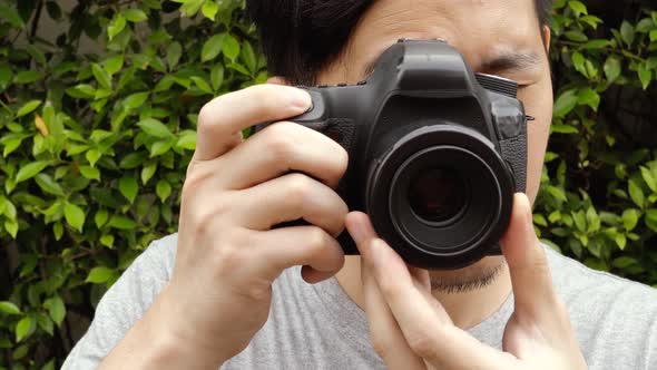 Close Up of Young Male Photographer Taking Photos in Nature Scenery