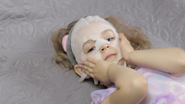 Teen Girl Applying Moisturizing Face Mask. Child Kid Take Care of Skin with Cosmetic Facial Mask