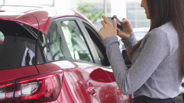 Cropped Shot of a Woman Taking Photos of Her New Car