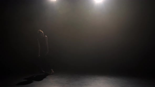 Young Artist Performing Tender Dance Steps in Dark