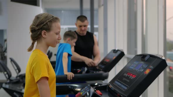 Coach Helps Children Perform Physical Exercises in Gym