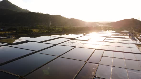 Breathtaking aerial flight over flooded sal fields with mountains and golden sunset in background -