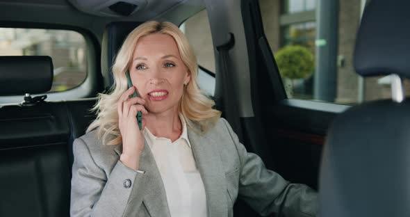 Attractive Adult Caucasian Businesswoman in Car Talking on Mobile Phone.