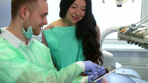 Dentist Explaines To the Client Something on His Tablet