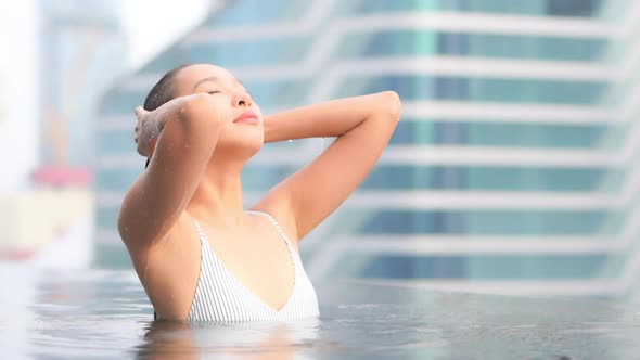 Young asian woman enjoy around outdoor swimming pool for leisure