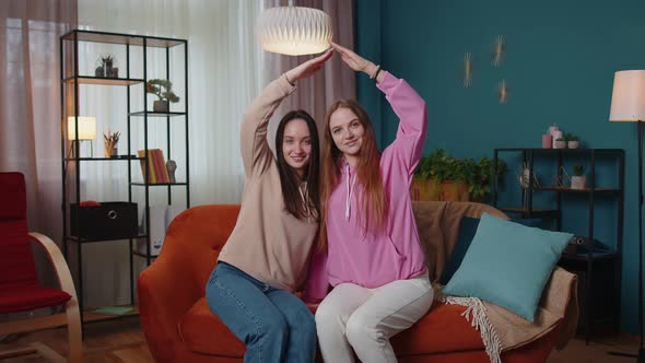 Happy Girls Siblings Making Roof Gesture Sign of Hands New Home Ownership Insurance Bank Loan
