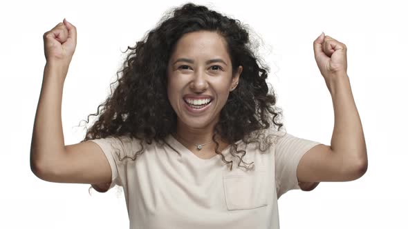 Closeup of Attractive Curlyhaired Woman in Casual Tshirt Jumping From Happiness Winning Something