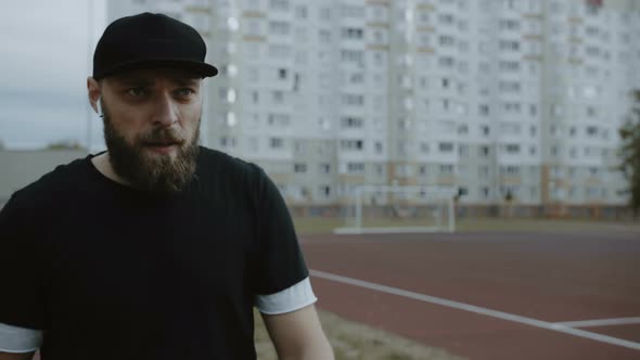 Young Motivated Male Athlete Preparing To Run on Track, Setting Timer on Smart Watch and Starting To