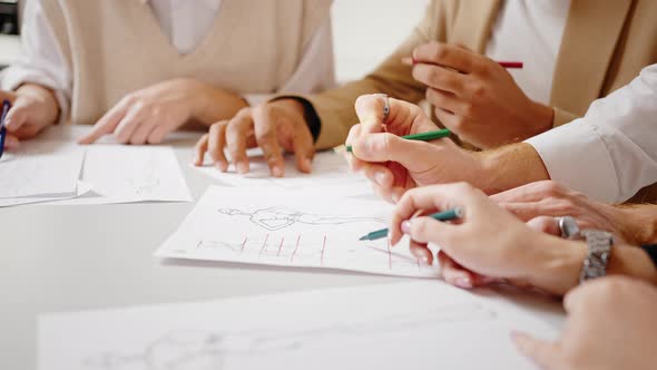 Close Up Shot of Fashion Designers Hands Drawing Dress Sketches Studying to Create Dress with Female