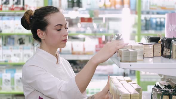 A Female Pharmacist Is Looking at Some Products on the Shelf