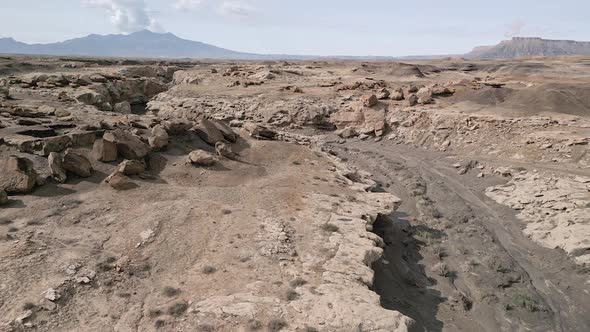 Flying over desert landscape with canyon were flash floods flow