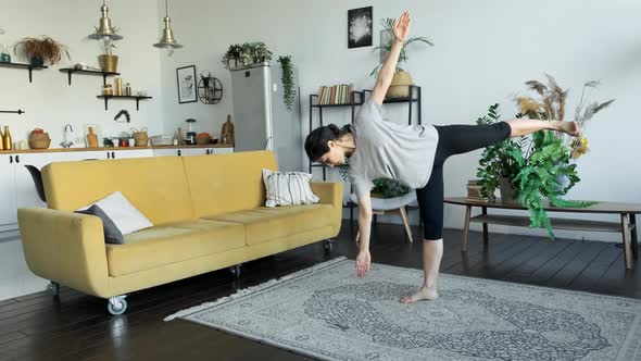 A Young Indian Woman Does Yoga Meditation At Home, Does A Balance Exercise, Stands On One Leg