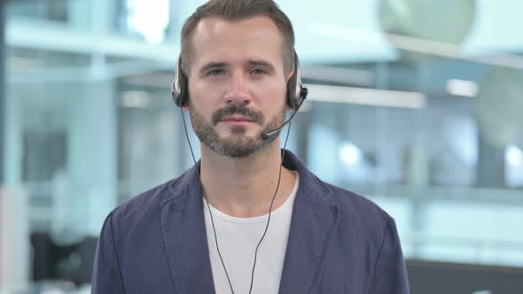 Middle Aged Businessman with Headset Looking At Camera