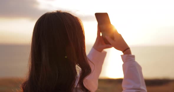 Woman Take a Photo of Sunset