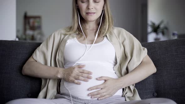 Front View of Expectant Mother Resting on Sofa with Closed Eyes