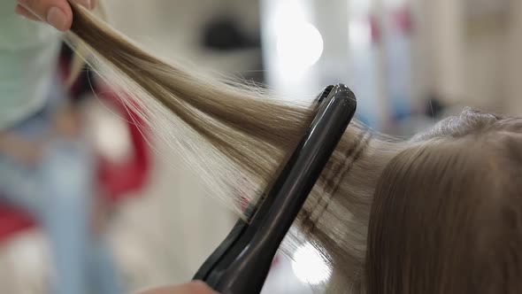 Professional Hairdresser Working with Model Hair. Straightening Corrugated Iron