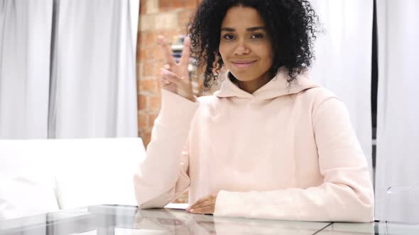 AfroAmerican Woman Gesturing Victory Sign Indoor