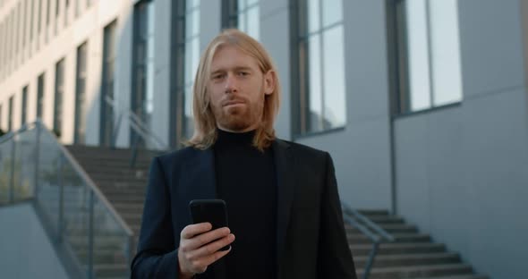 Portrait of Man Raising and Looking To Camera While Using Smartphone, Crop View of Handsome