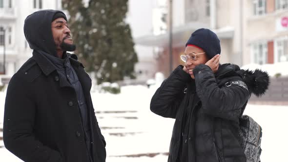 African American Couple in Warm Clothes Walking in the Winter City Together