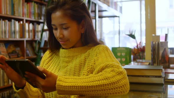 Teenage girl using digital tablet in library 