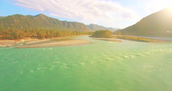 Low Altitude Flight Over Fresh Fast Mountain River with Rocks at Sunny Summer Morning.