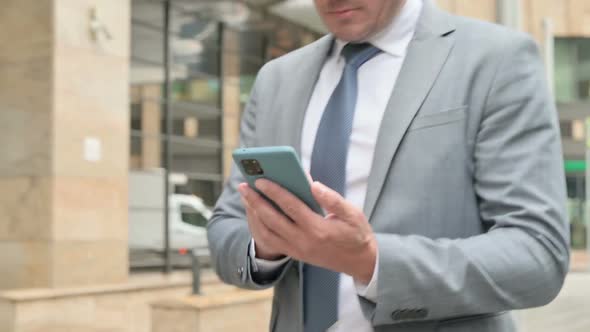 Close Up of Male Hands Using Smartphone while Walking on Street