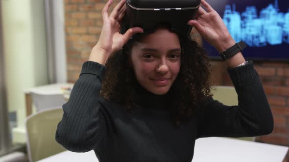 Creative businesswoman using virtual reality headset in modern office