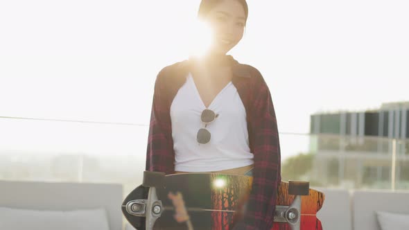 Attractive Asian woman smiling  play skateboard outdoor