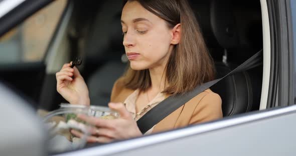 Business Woman Eating a Salad on the Driver's Seat of Her Car