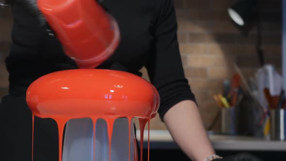 Woman Pastry Chef Decorates Mousse Cake with Red Icing