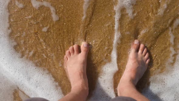 Men's Feet Are Washed By the South Sea on a Sandy