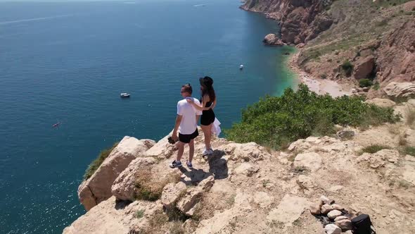 Couple Stands on a Rock Near the Sea