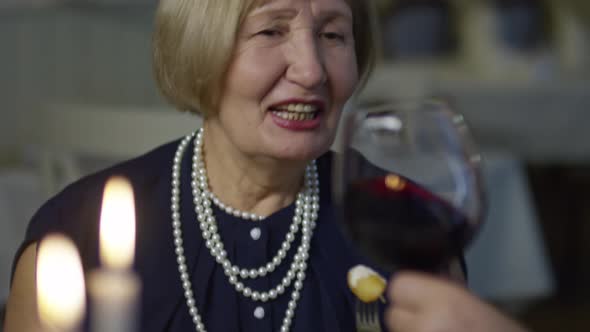 Senior Woman Having Dinner in Restaurant