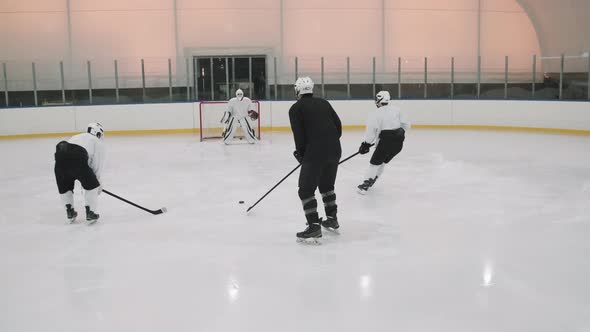 Hockey Players Practicing Puck Shooting Into Net