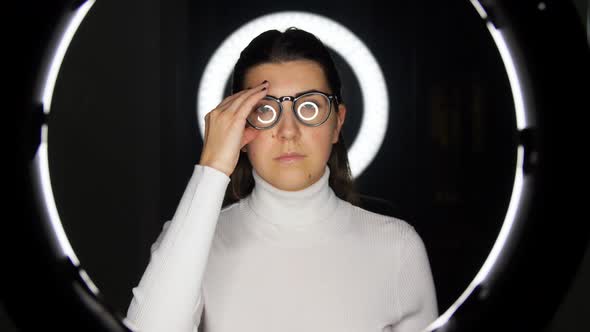 Woman in Glasses Over White Illumination on Black