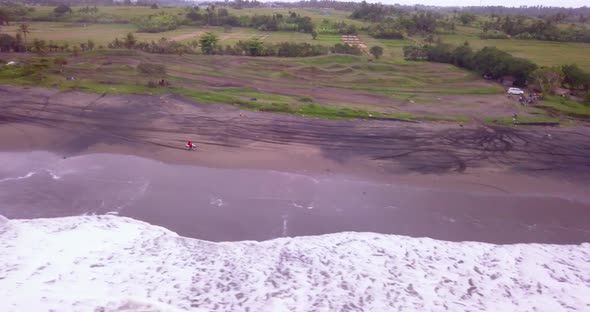 Aerial drone view of a man riding his motocross motorcycle on the beach