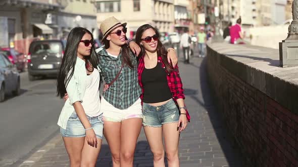 Three happy women walking in the city