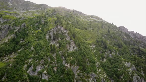 aerial drone view of the rocky facade of a mountain in the swiss alps.