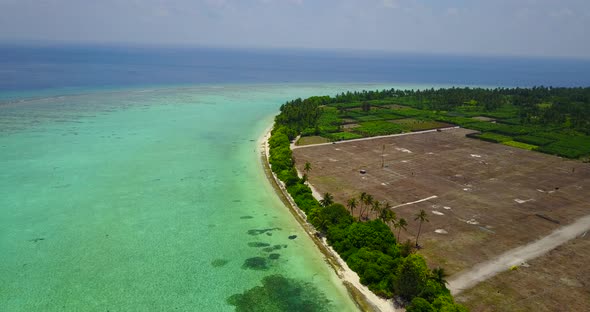 Daytime drone travel shot of a sunshine white sandy paradise beach and blue ocean background in high