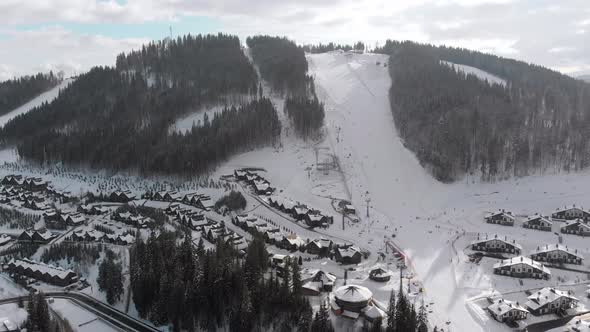 Aerial View of Ski Resort with Ski Slopes and Skiers, Snowy Fir Forest, Bukovel