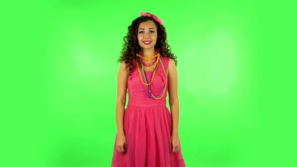 Pretty Girl Looks Into the Camera and Then Pulls Her Hands in Front and Having Fun. Green Screen