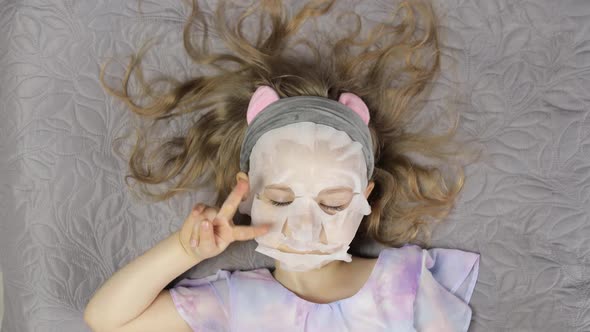 Teen Girl Applying Moisturizing Face Mask. Child Kid Take Care of Skin with Cosmetic Facial Mask
