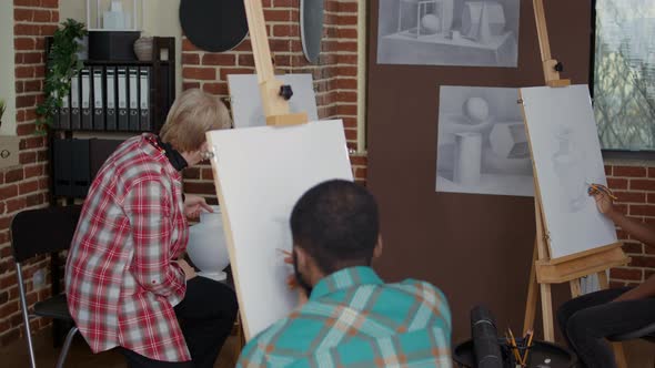 Elder Teacher Explaining Drawing Technique to Students in Art Class