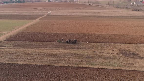 Aerial View of Amish Farm Worker Turning the Field in Early Spring