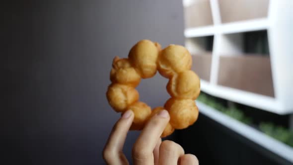 Handheld slow motion push towards hand holding pon de ring mochi donut