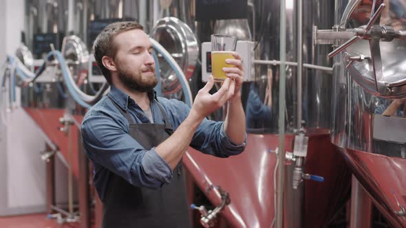 Brewery Worker With Glass Of Freshly Made Beer