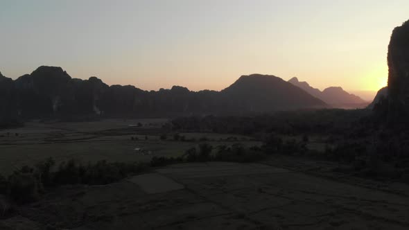 Aerial: Vang Vieng backpacker travel destination in Laos, Asia. Sunset