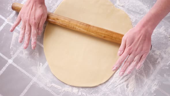 Apple Pie Preparation Series  Woman Rolling Out Dough with Pin on a Table