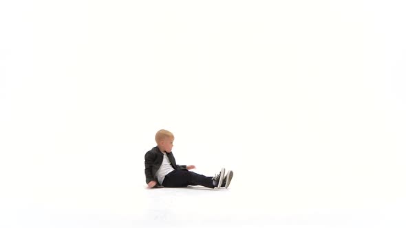 Little Boy Is Dancing a Modern Dance on the White Background in Black Leather Jackets and Jeans