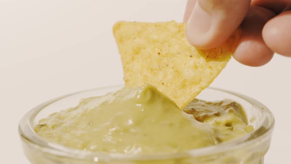 Dipping Tortilla Chip Into Guacamole Sauce